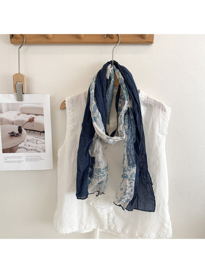 Navy floral patchwork scarf looped over a white top with both ends hanging down.