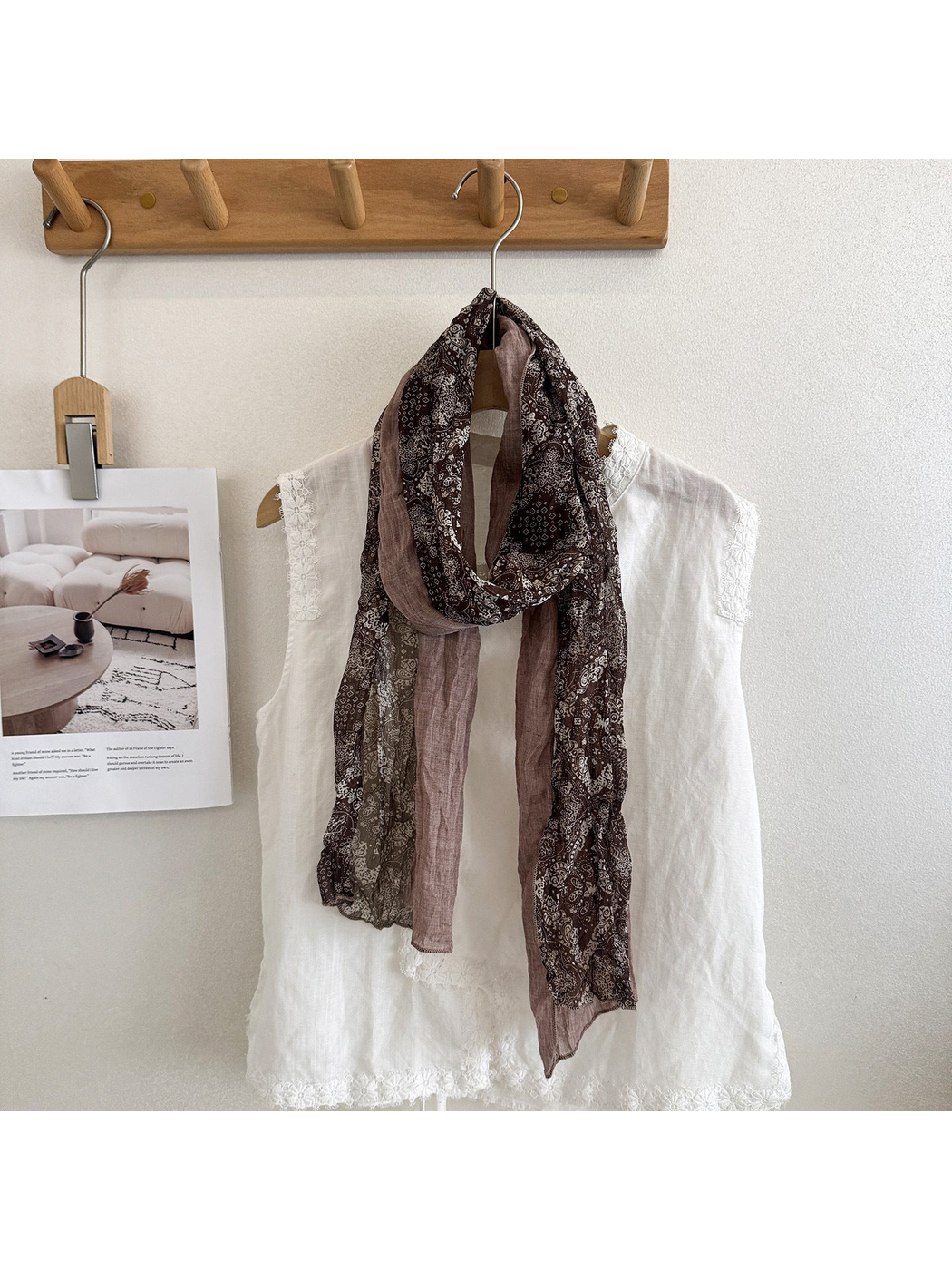 Coffee scarf with pale paisley motifs and contrasting solid sections, looped over a white top.