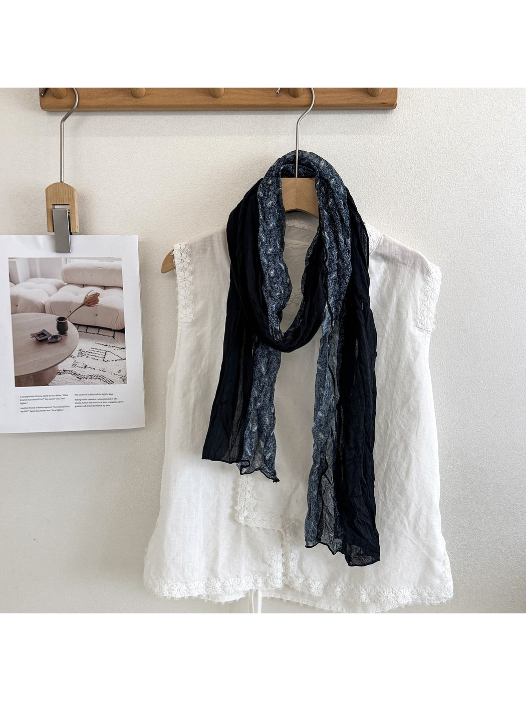 Navy scarf with solid and paisley sections looped over a white top.