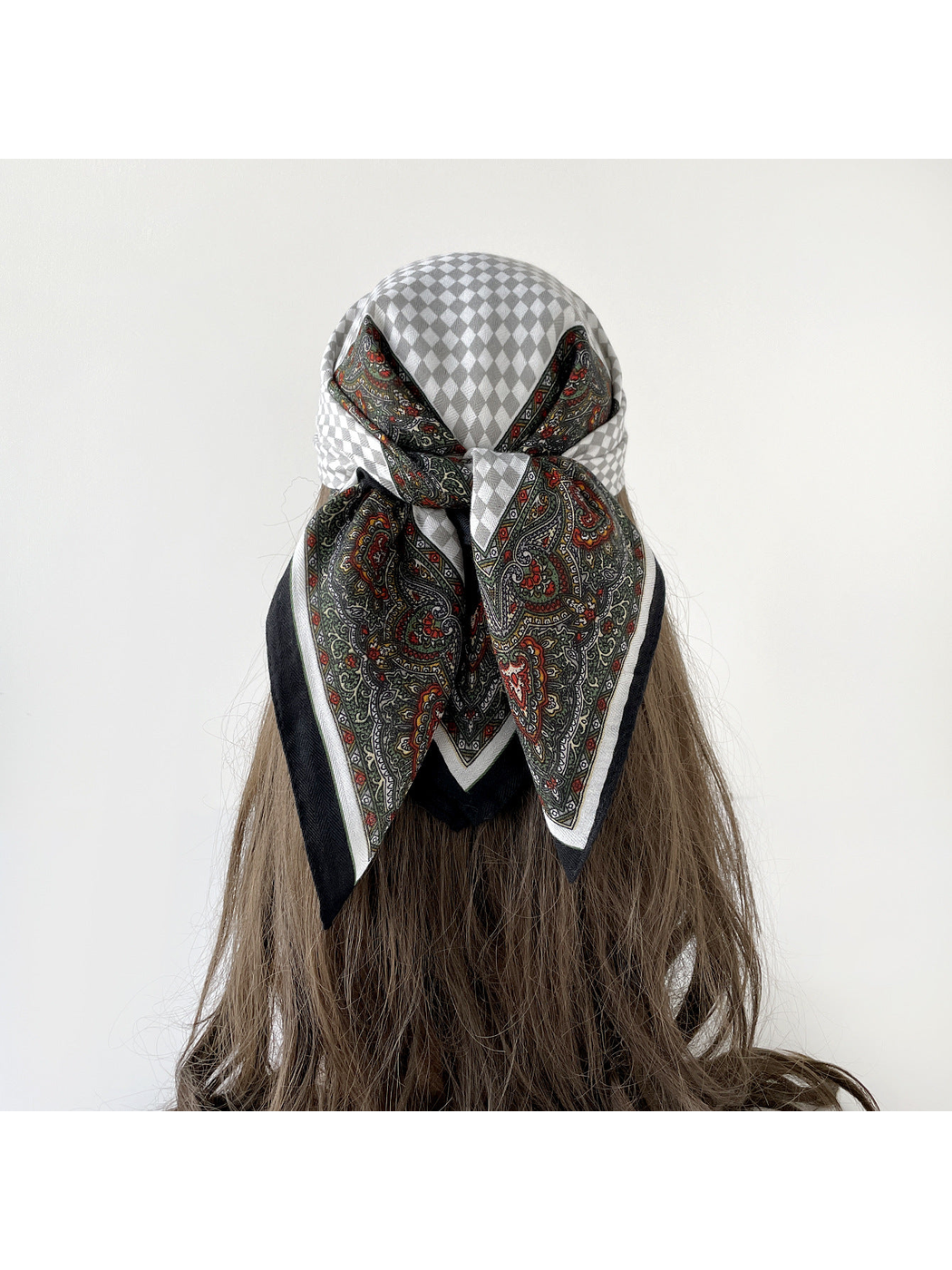 Black Gray checkerboard and paisley scarf tied as a headscarf, viewed from behind.