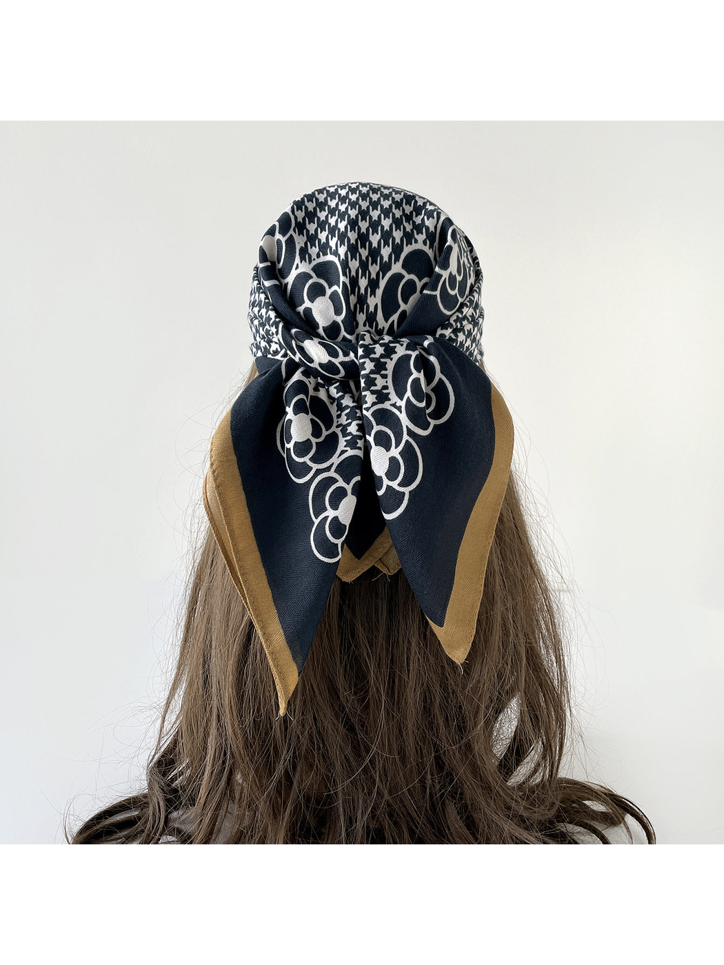 Navy floral and houndstooth scarf tied over the hair, viewed from behind.