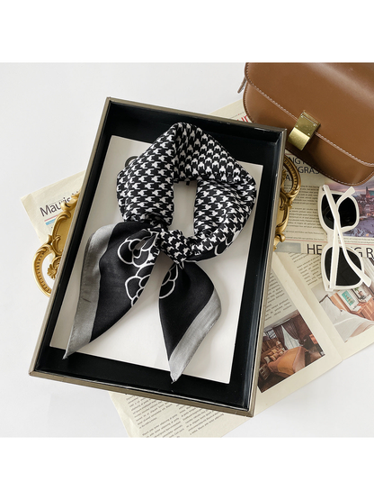 Black Gray scarf arranged in a knotted loop with white houndstooth and floral motifs.