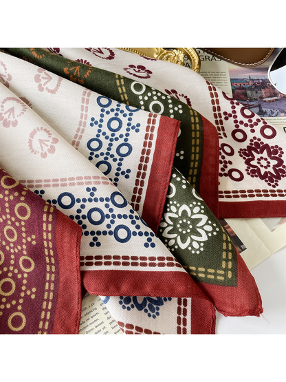 Close-up of the Burgundy scarf's herringbone texture, floral motifs, dotted rings, and red edge.
