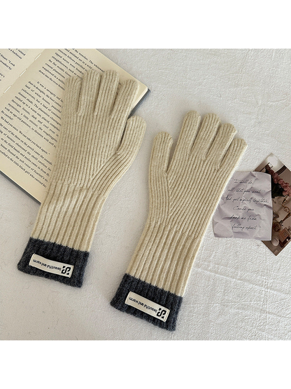 Ivory ribbed gloves with dark gray cuffs and rectangular labels.