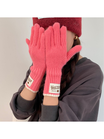 Person wearing Rose Pink ribbed gloves with both hands raised in front of their face.