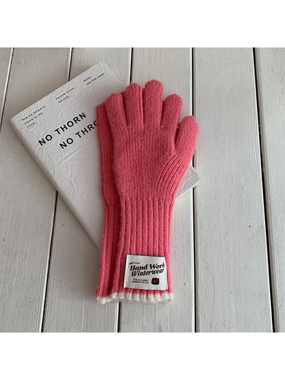 Rose Pink ribbed gloves with cream cuff edges and a rectangular patch, laid flat.