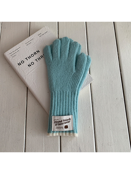 Lake Blue ribbed gloves with cream cuff edges and a rectangular patch, laid flat.