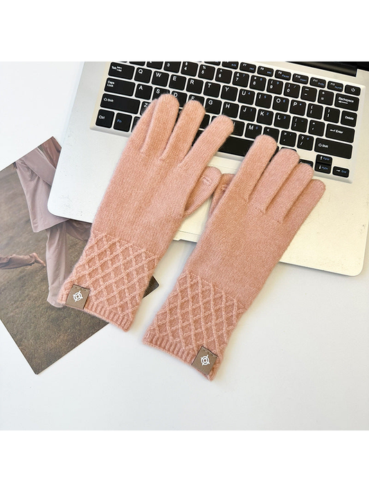 Blush Pink knit gloves with clearly defined diamond lattice cuffs beside a laptop.