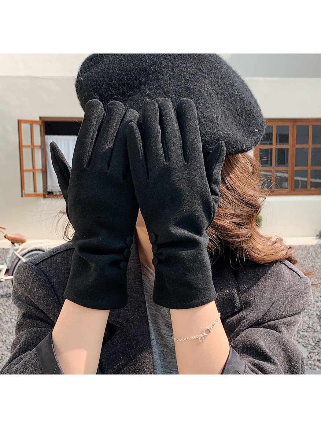 Black gloves worn with both hands raised in front of the face.