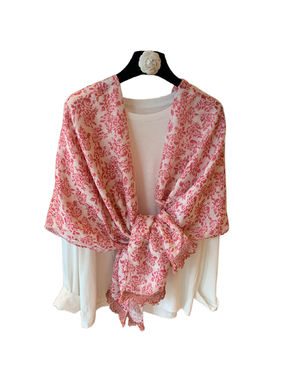 Pink floral scarf draped and tied over a white top