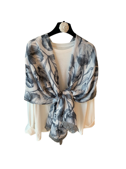 Gray-blue and ivory floral scarf tied over a cream top, front view
