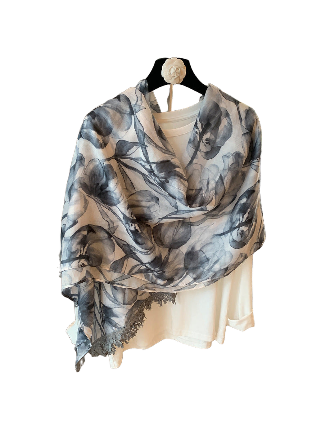 Gray-blue and ivory floral scarf draped over a cream top, back view