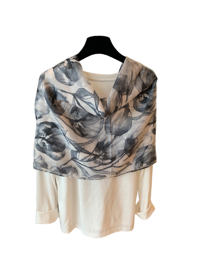 Gray-blue and ivory floral scarf draped over a cream top, rear view