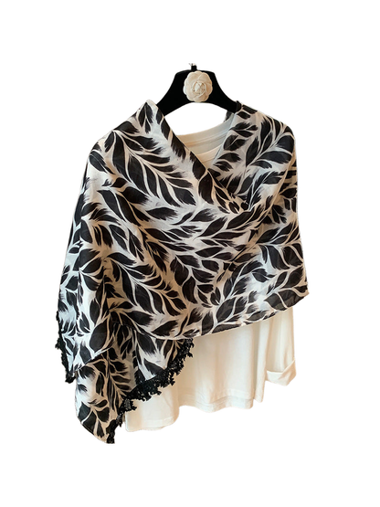 Black-and-white rectangular scarf with a leaf pattern and black lace trim, folded front view