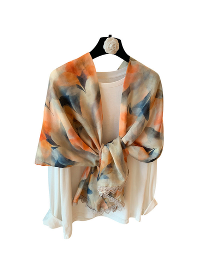 Multicolor abstract floral scarf with lace trim tied over a white top, front view