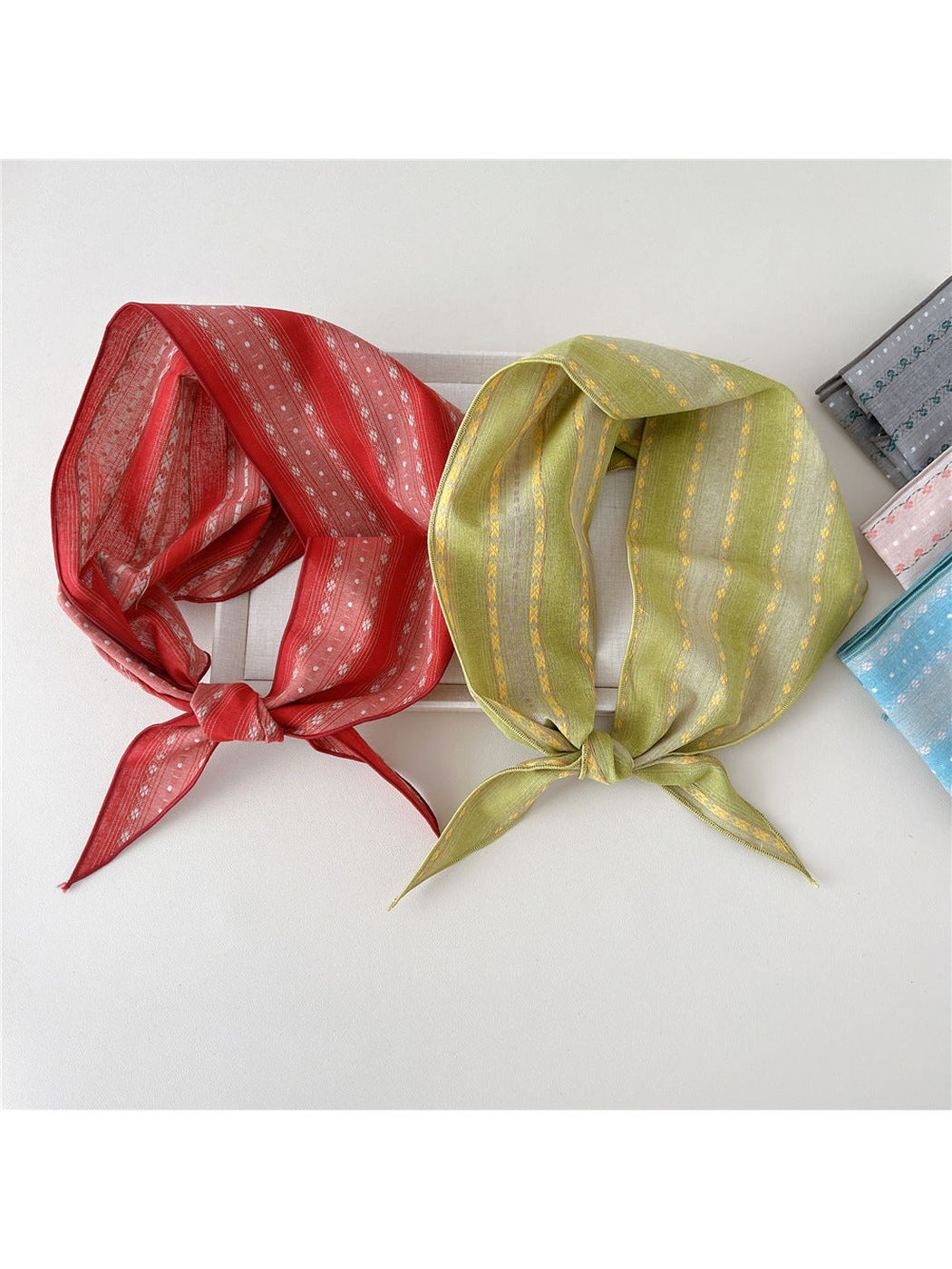 Red and yellow floral triangle scarves displayed together with additional colorways