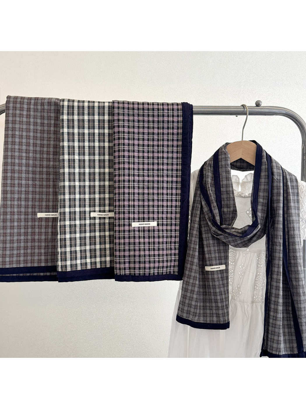 Plaid scarves displayed together on a clothing rack