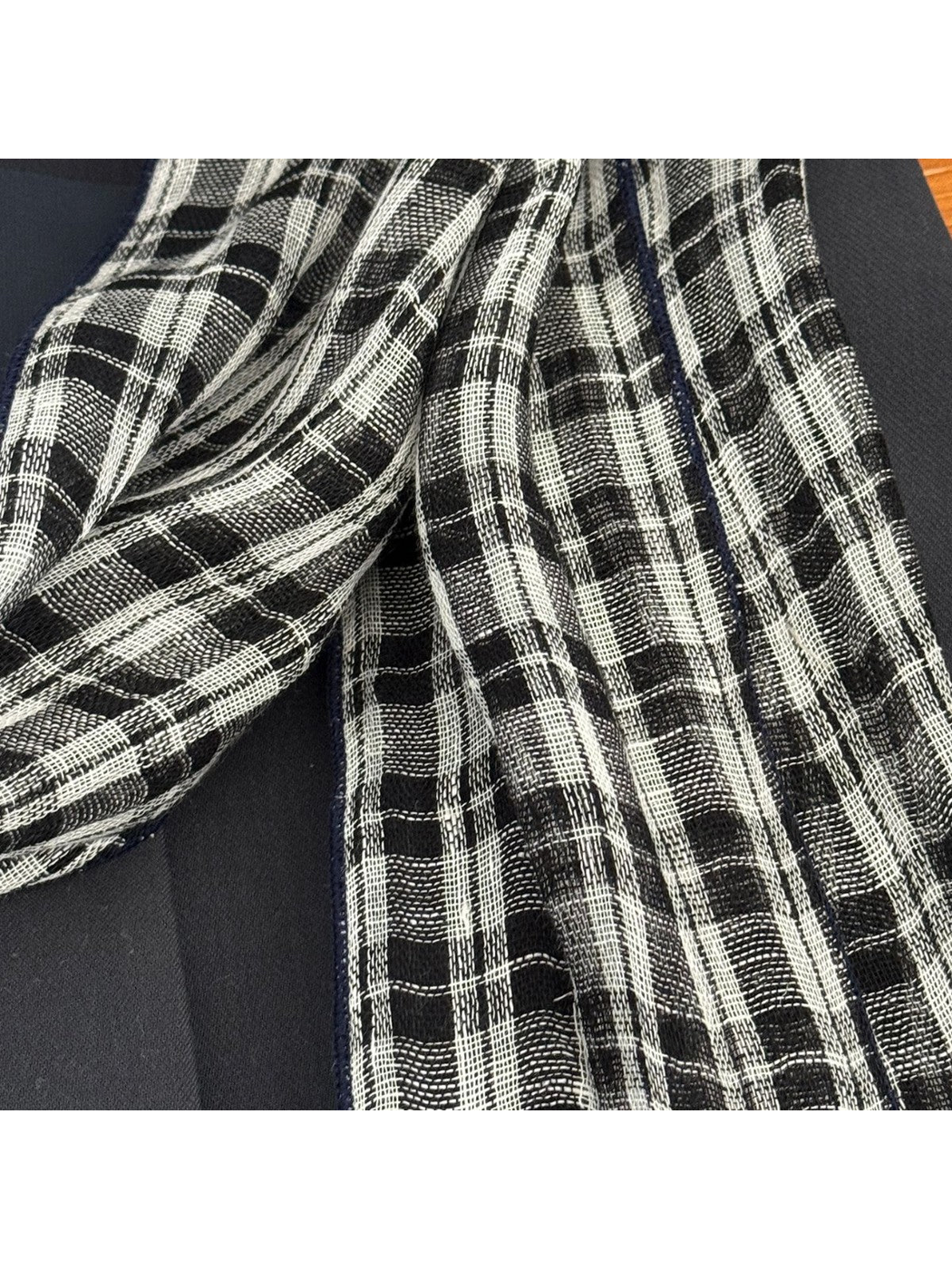 Close-up of the scarf's open weave and plaid pattern
