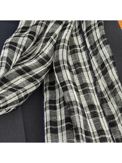 Close-up of the scarf's open weave and plaid pattern
