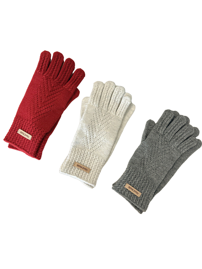 Red, ivory, and gray gloves arranged beside a laptop