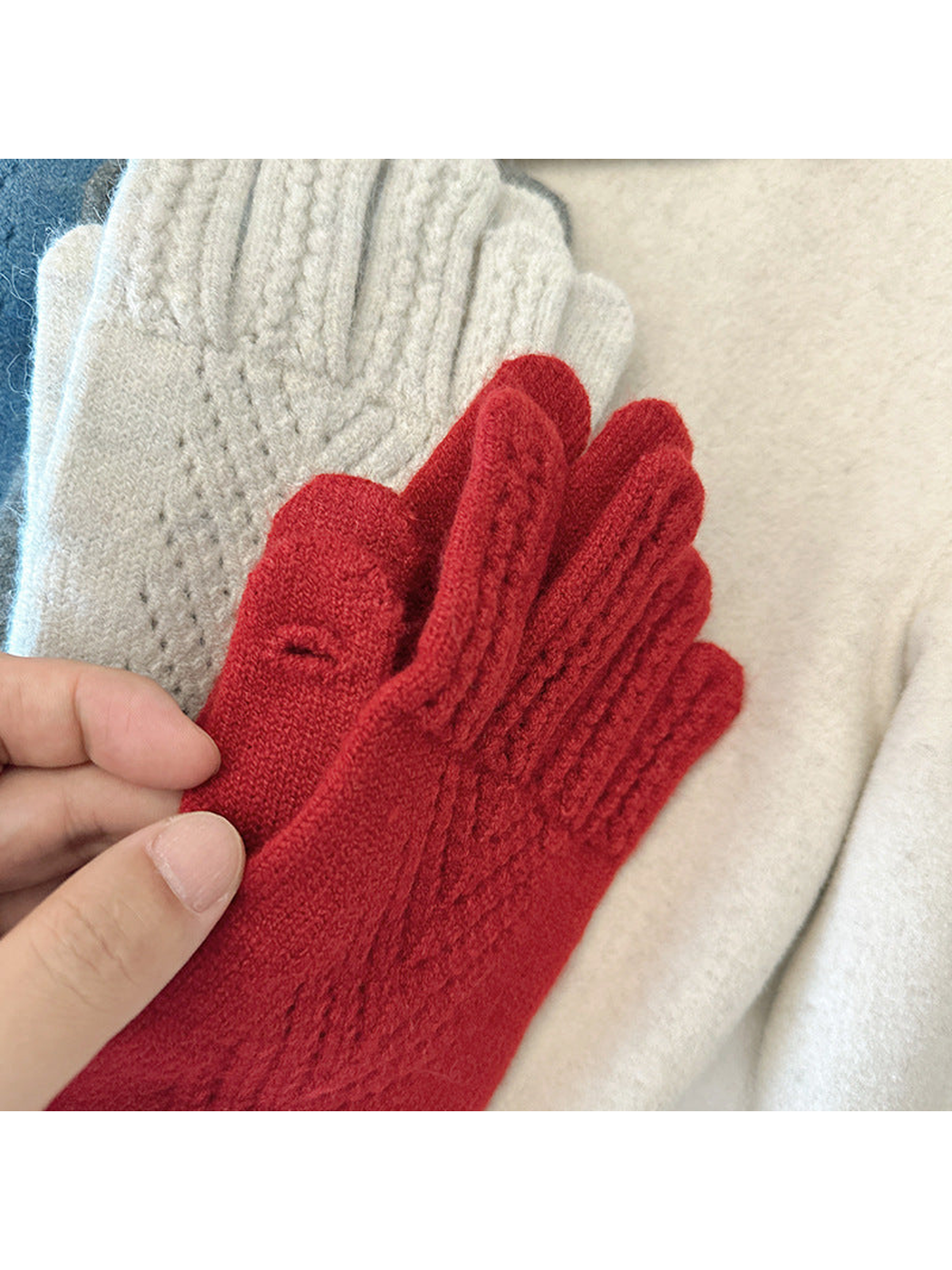 Close-up of a red glove showing the finger sections and openwork pattern