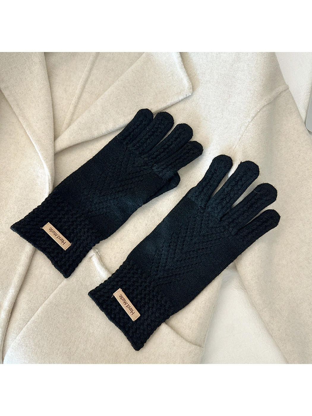 Black five-finger gloves with textured cuffs and chevron-like openwork lines