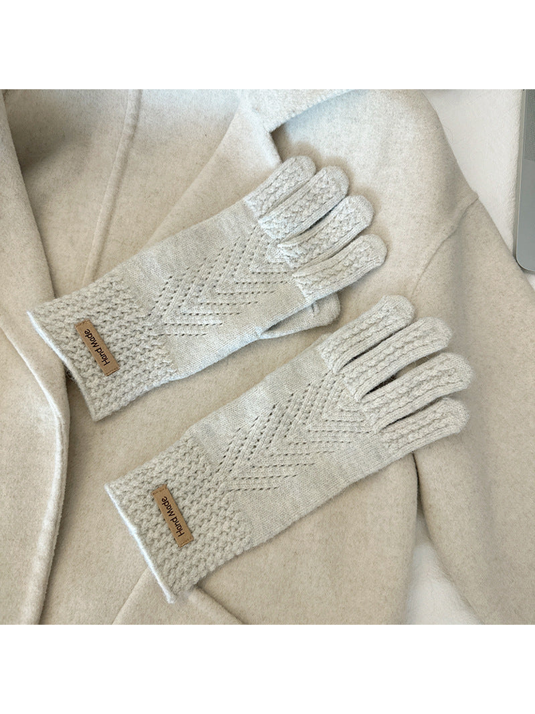 Ivory five-finger gloves with textured cuffs and chevron-like openwork lines