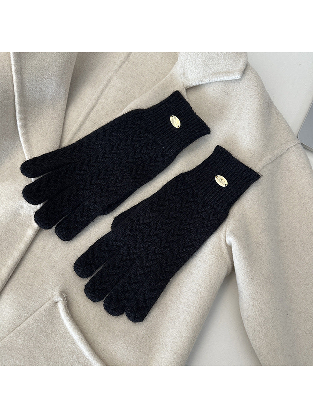 Black five-finger gloves with a repeating chevron knit pattern