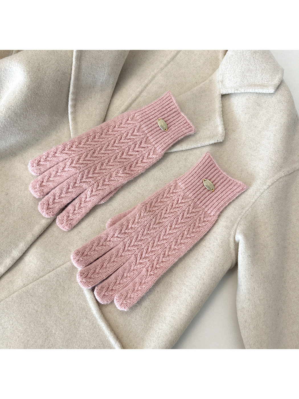 Pink five-finger gloves with a repeating chevron knit pattern