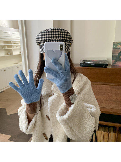 Blue gloves with brown cuffs worn while taking a mirror photo