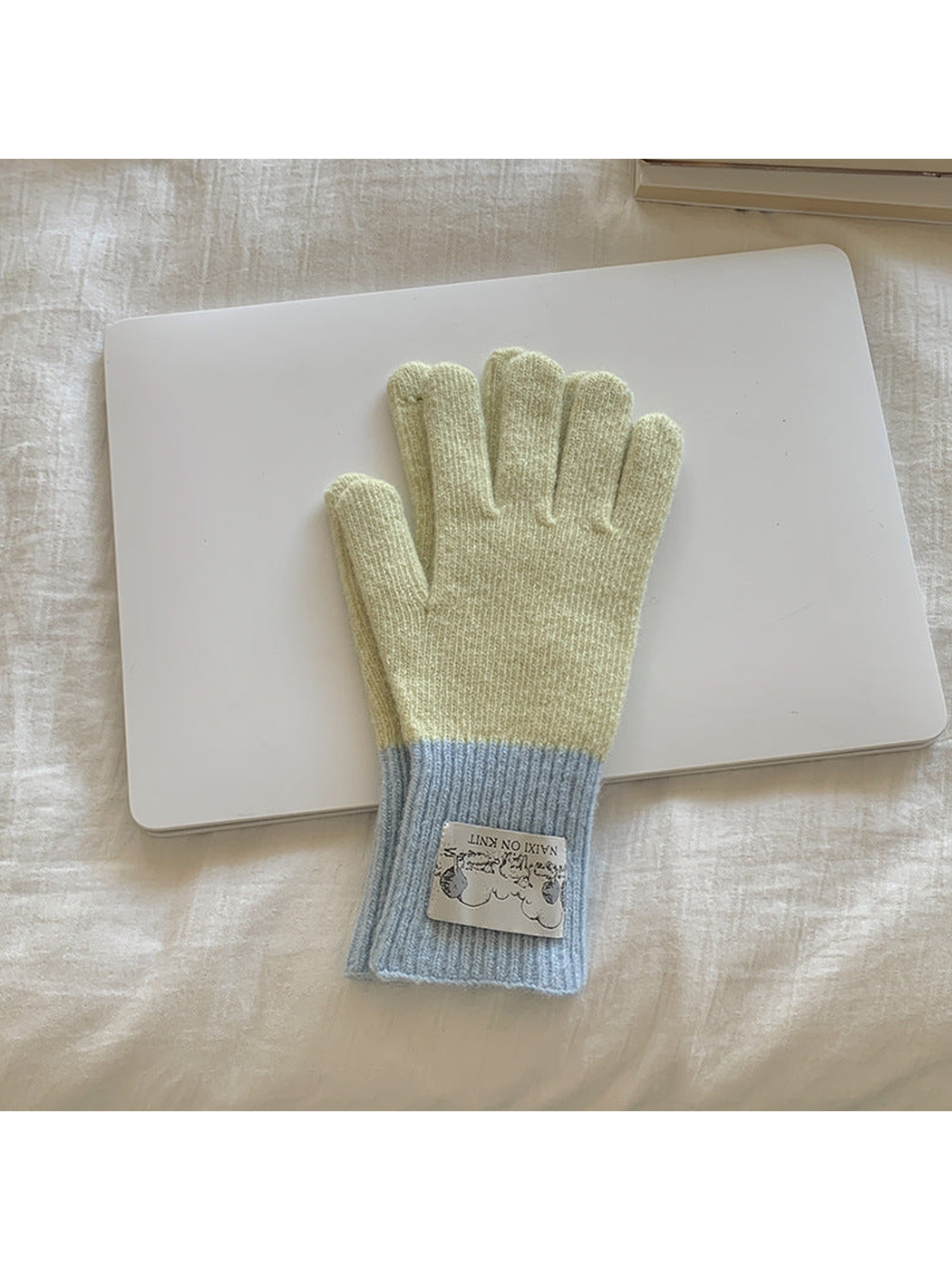 Beige gloves with light blue cuffs, front view