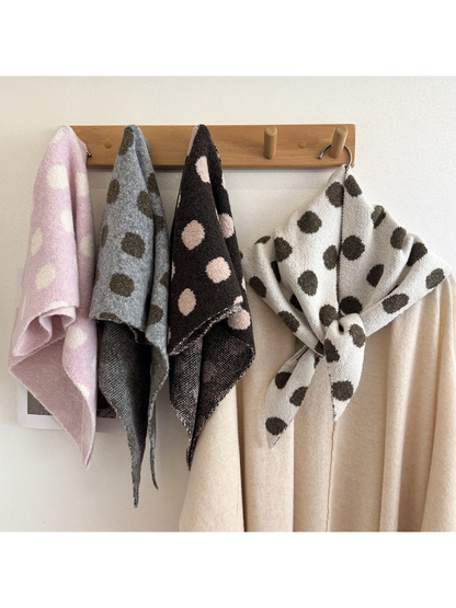 Multiple polka-dot scarf colors displayed on a wooden wall rack