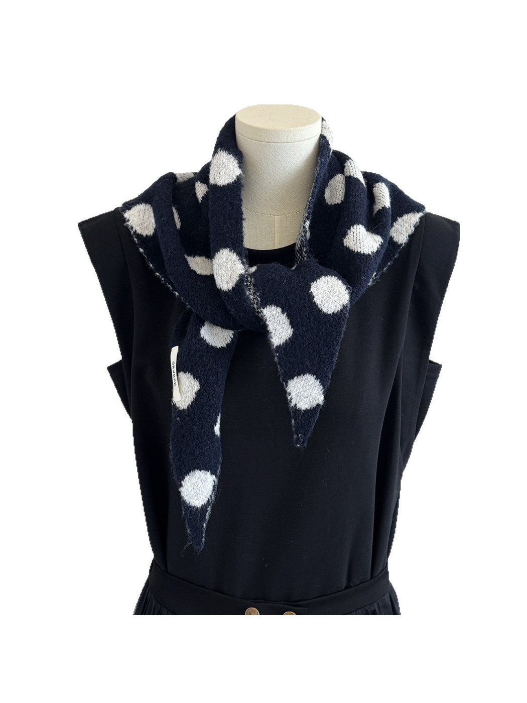 Navy and white polka-dot scarf draped on a black mannequin against a white background
