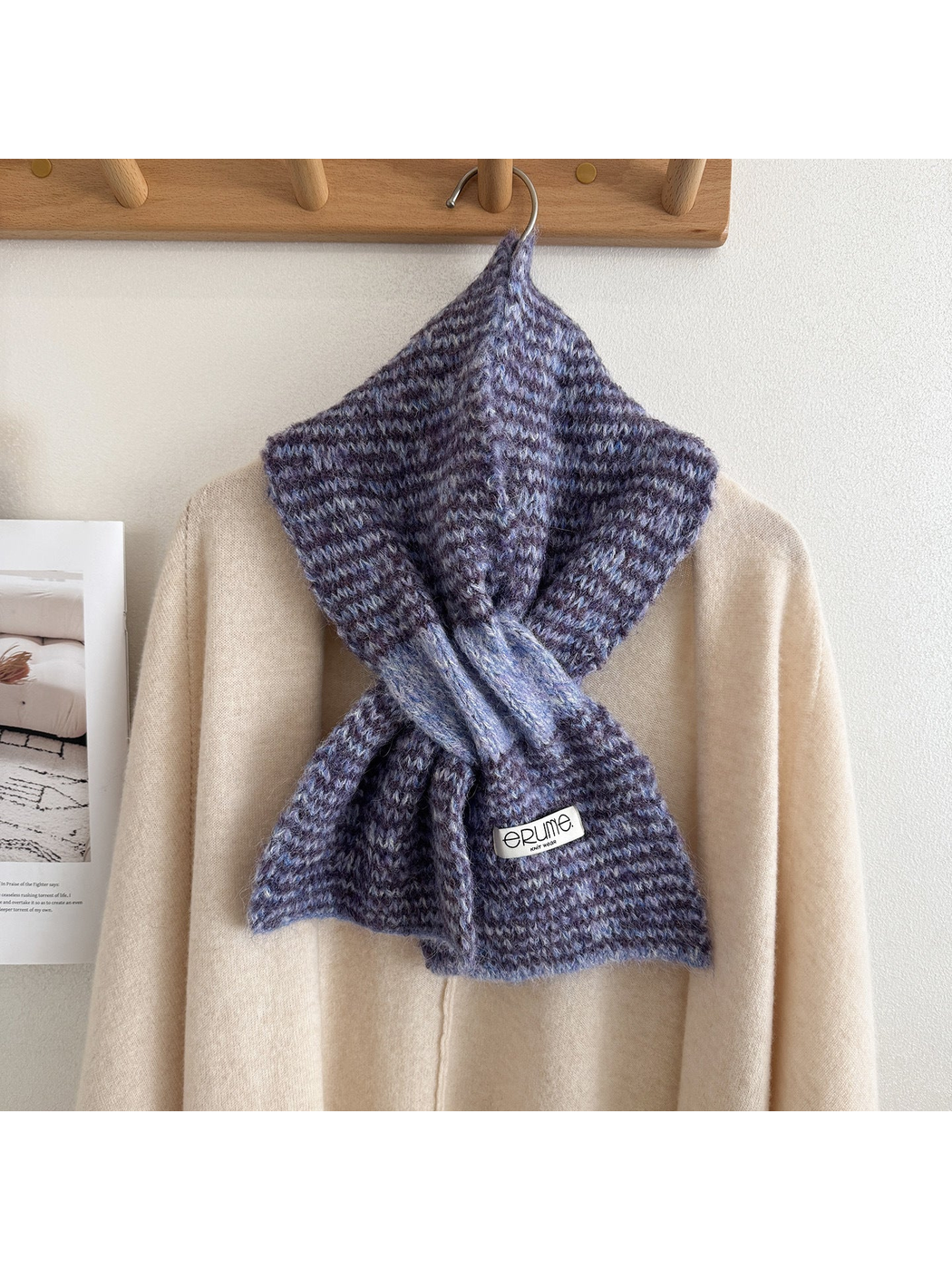 Purple scarf draped around the neck of a cream sweater