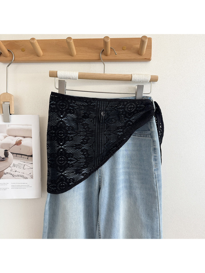 Black lace triangle scarf draped over light denim
