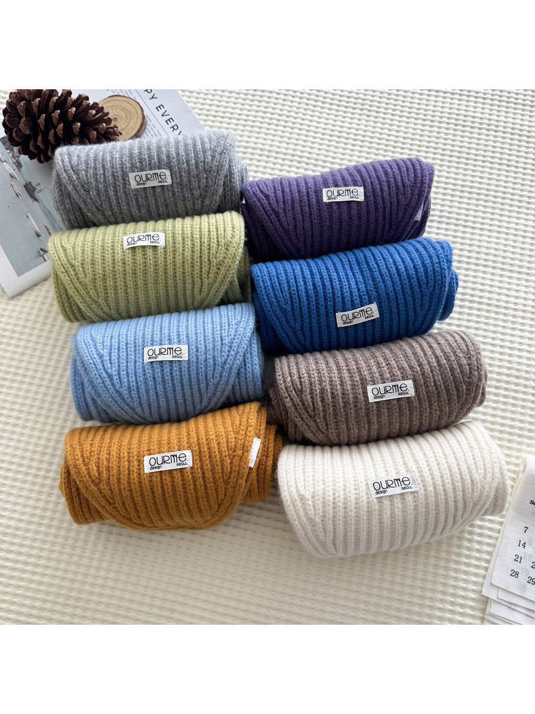 Multiple colors of ribbed knit scarves arranged in rolled views