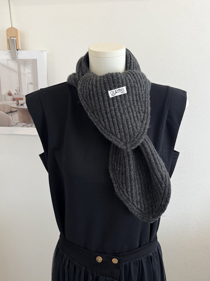 Dark gray ribbed knit scarf with pointed ends on a mannequin