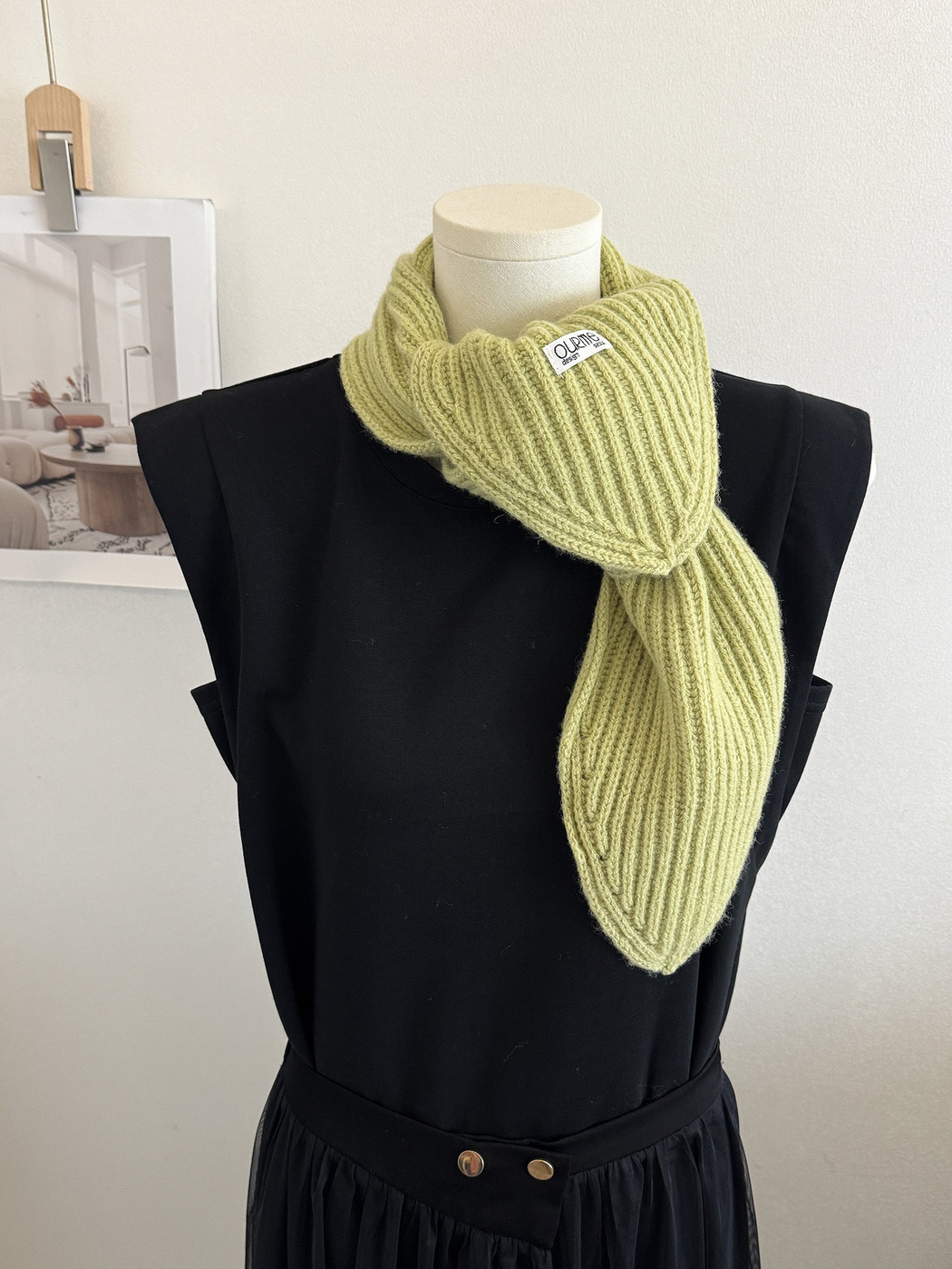 Light green ribbed knit scarf with pointed ends on a mannequin