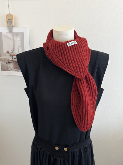 Burgundy ribbed knit scarf with pointed ends on a mannequin