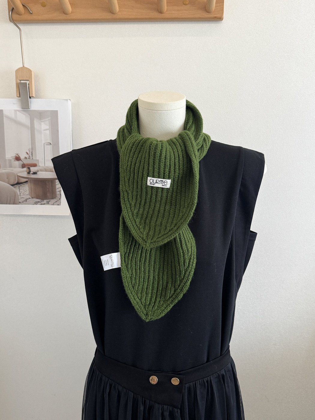 Army green ribbed knit scarf with pointed ends on a mannequin