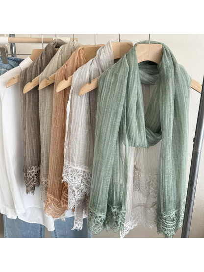 Narrow scarves in assorted colors hanging on wooden hangers