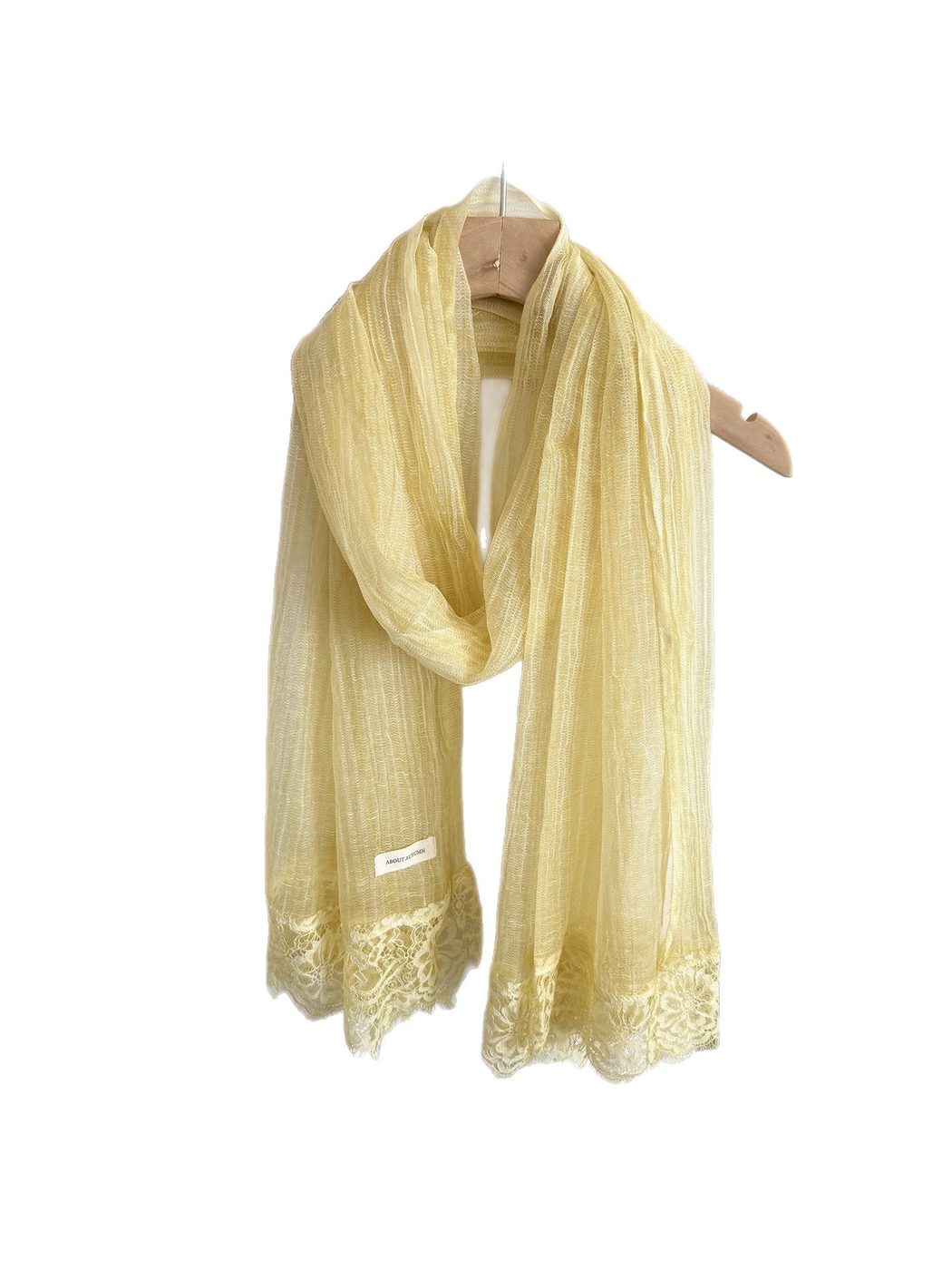 Yellow narrow scarf with floral lace trim, looped on a hanger