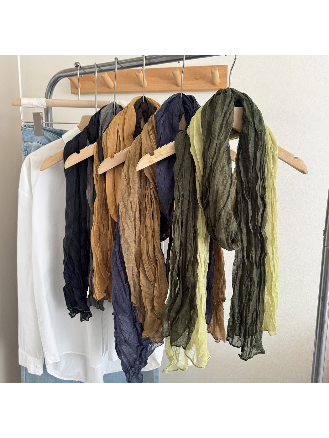 Multiple color-block scarves hanging on a clothing rack