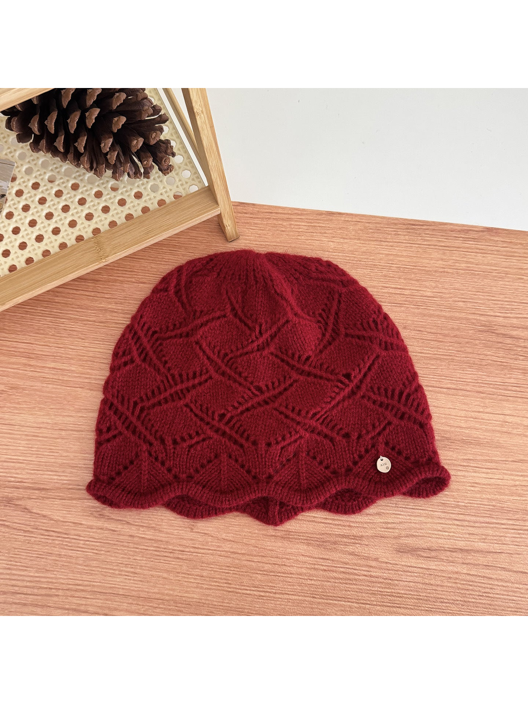 Burgundy cable-knit beanie with earflap and short visor-like brim