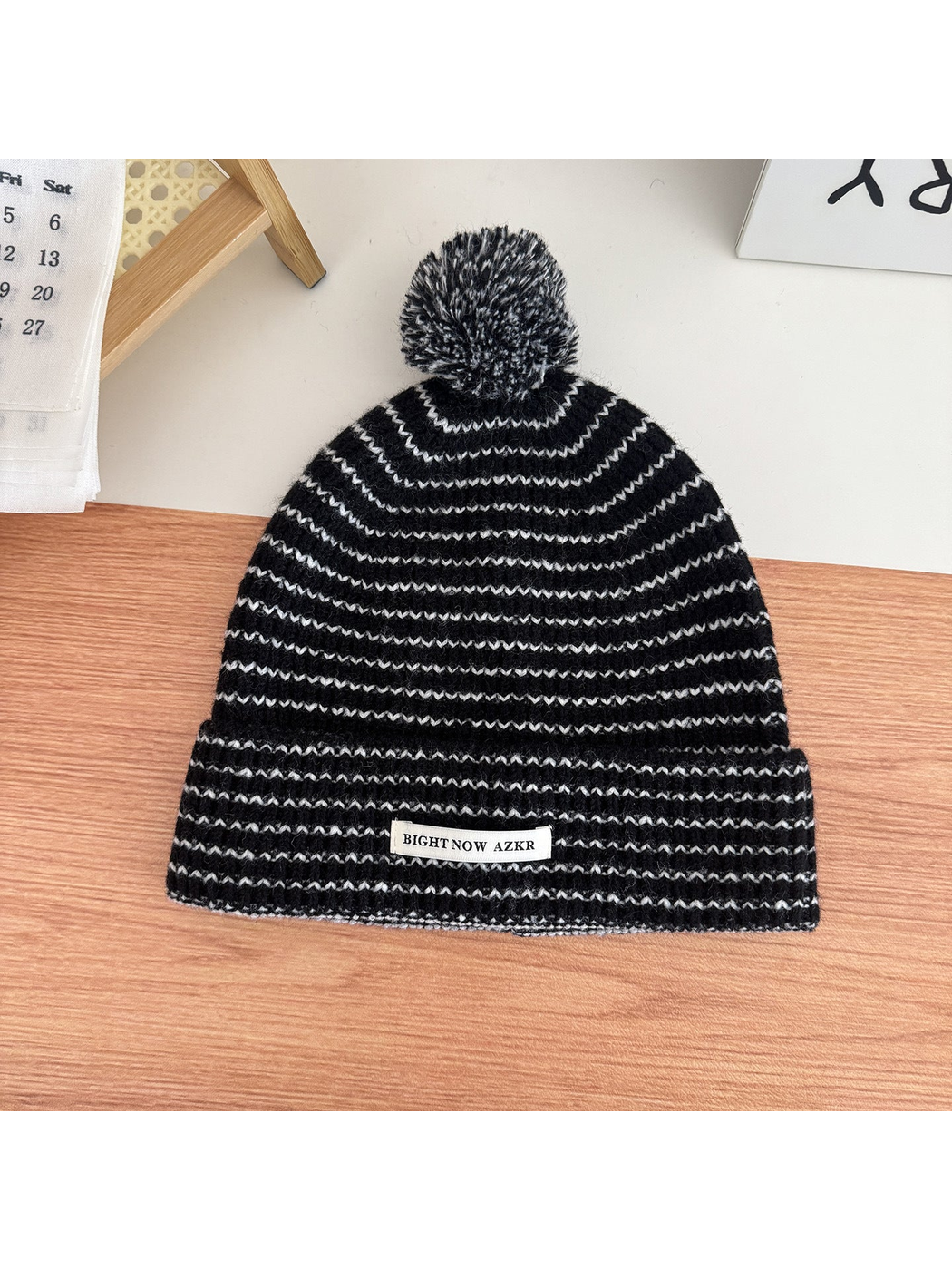 Black pom-pom beanie with wavy stripes and folded cuff