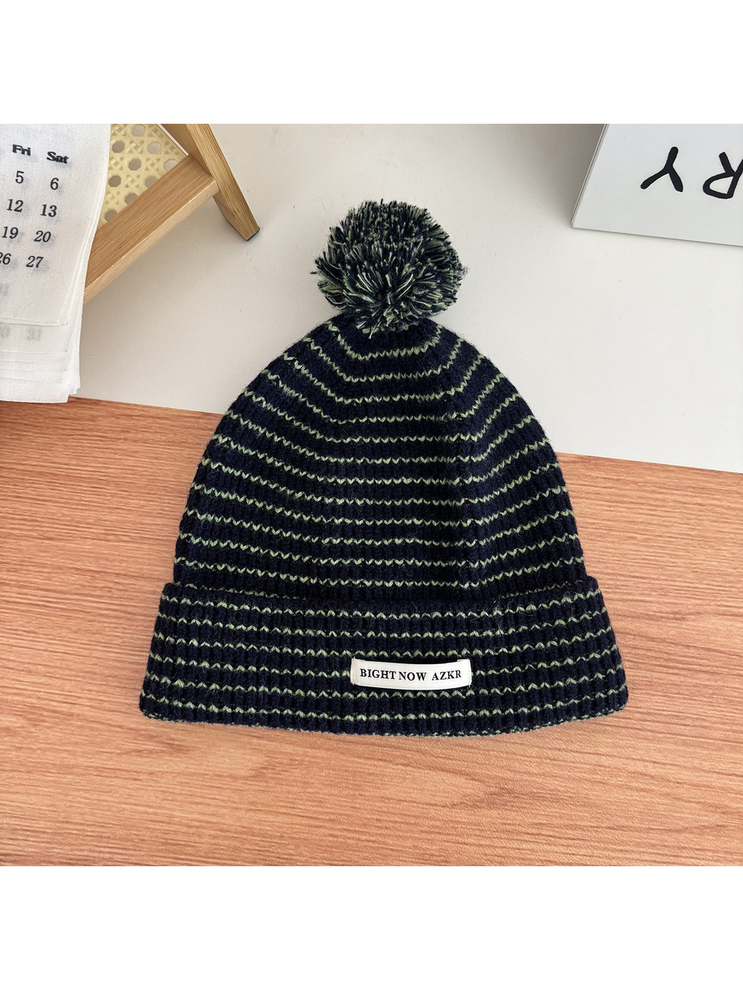 Navy pom-pom beanie with wavy stripes and folded cuff