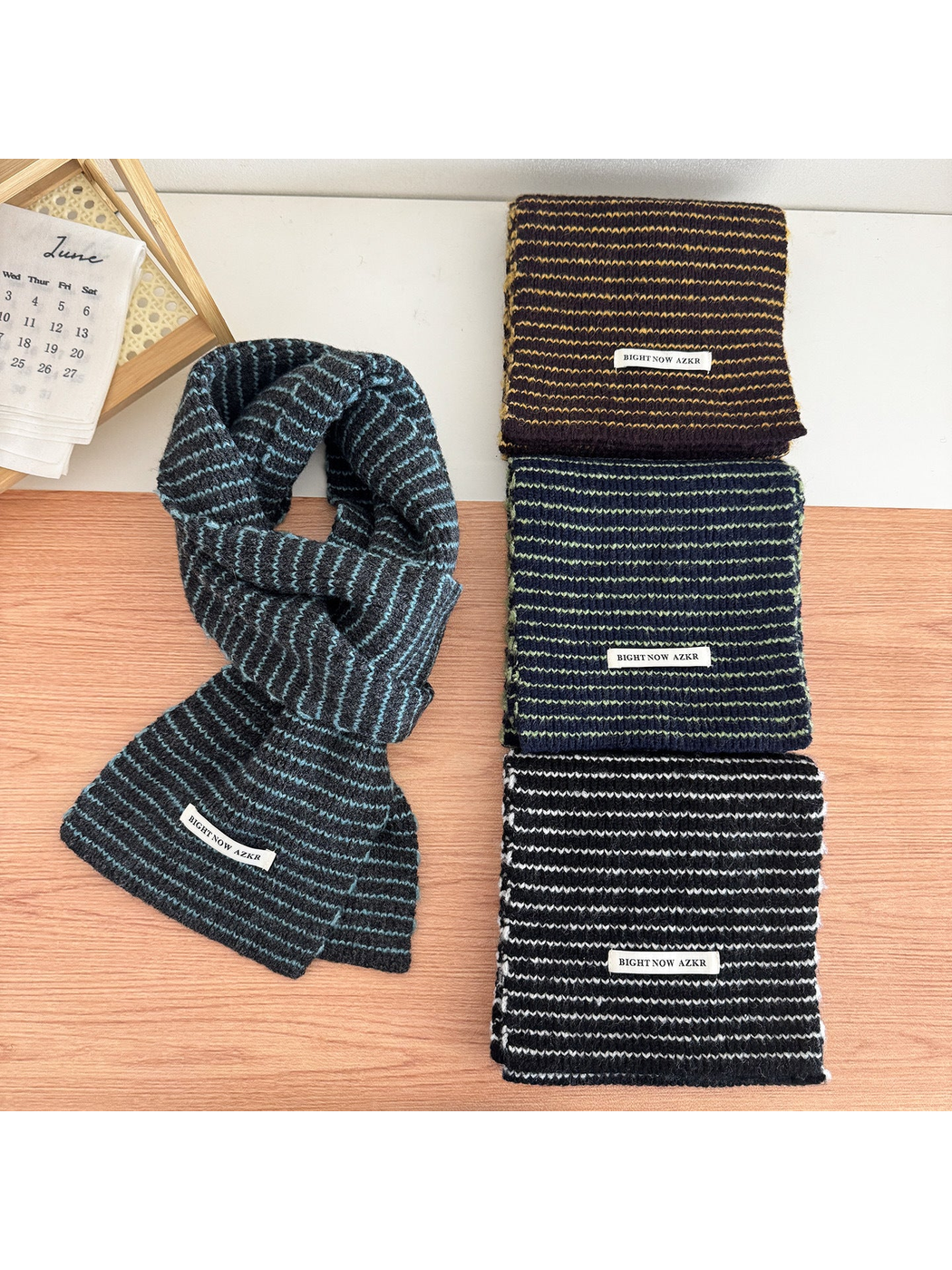 Four striped knit scarves displayed together on a tabletop