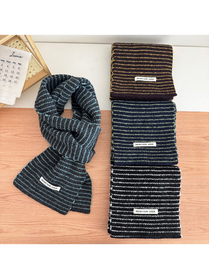 Four striped knit scarves displayed together on a tabletop