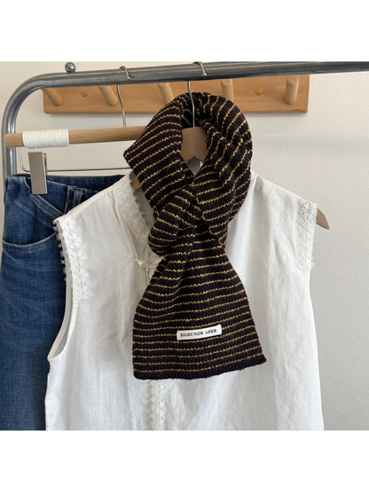 Dark brown striped knit scarf draped on a mannequin over a white blouse