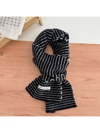 Black striped knit scarf looped on a tabletop